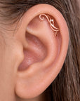Rose gold ornate helix piercing with a small diamond on a woman's ear