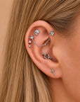 Elegant ear stack with floral, sword, and chain piercings in 18k gold, perfect for luxury body jewelry lovers.