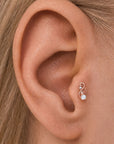 Rose gold butterfly ear piercing stud with a pearl and diamond on a human ear