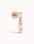 Rose gold ear piercing with dangling baguette-cut gemstones, luxury 18k gold body jewelry