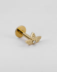 18k gold leaf-shaped piercing with center gemstone on white background