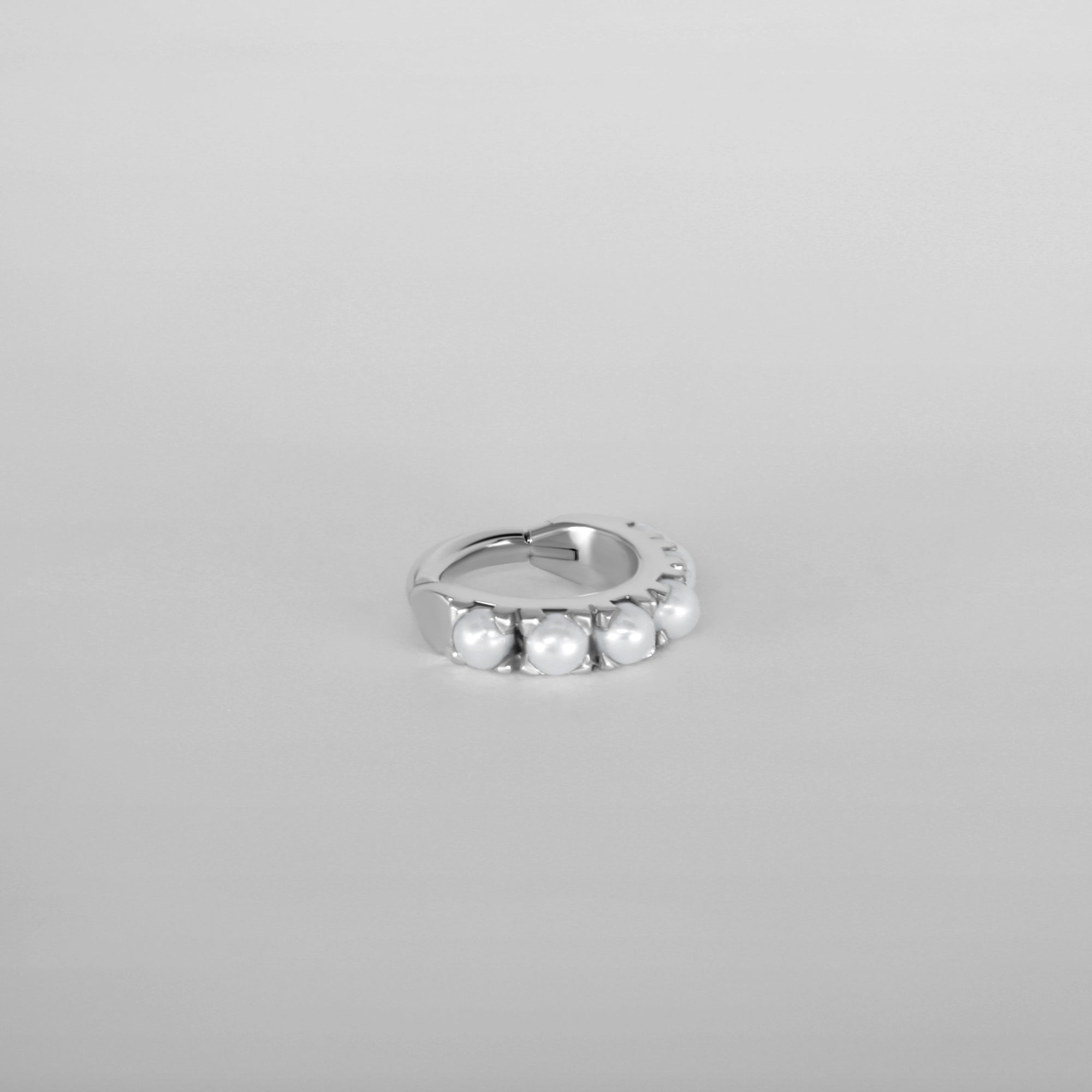 Close up for the Luméa hoop piercing, handcrafted in Paris in 18k white gold with pearls