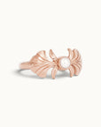 Rose gold ring featuring a central pearl and sculpted wing-like designs