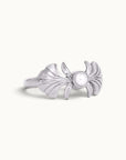 Silver shell-inspired ring featuring a central white pearl on a plain white background
