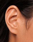 18k gold sword stud earring in ear, luxury piercing jewelry for elegant style