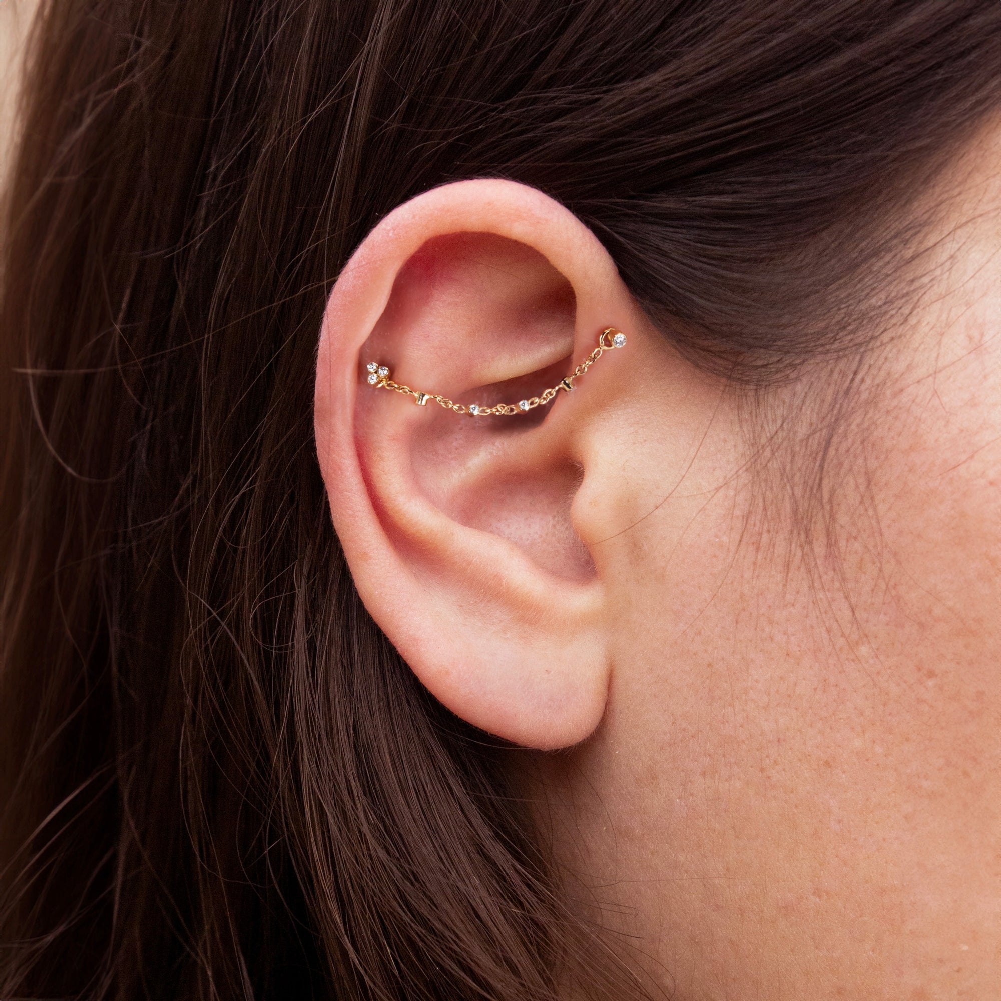 A model wearing our 18K rose gold piercing chain set with G-VS diamonds