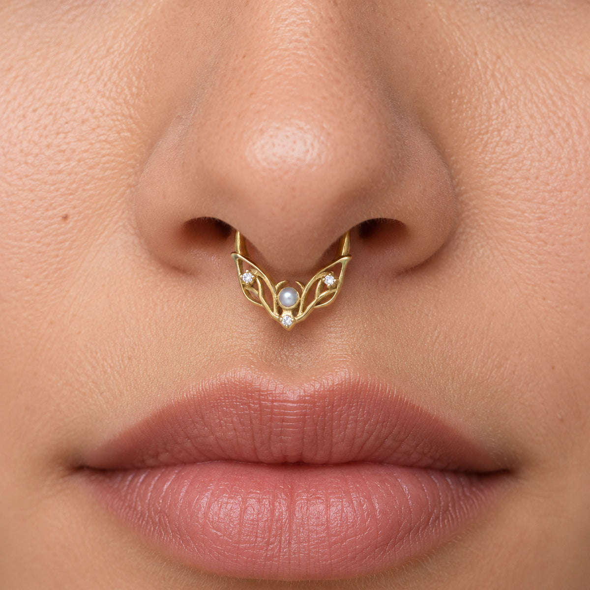 18k gold septum ring with pearls and diamonds on a woman's nose