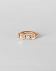 Close-up of Anneau Baya hoop piercing in 18k rose gold, minimalist and elegant design