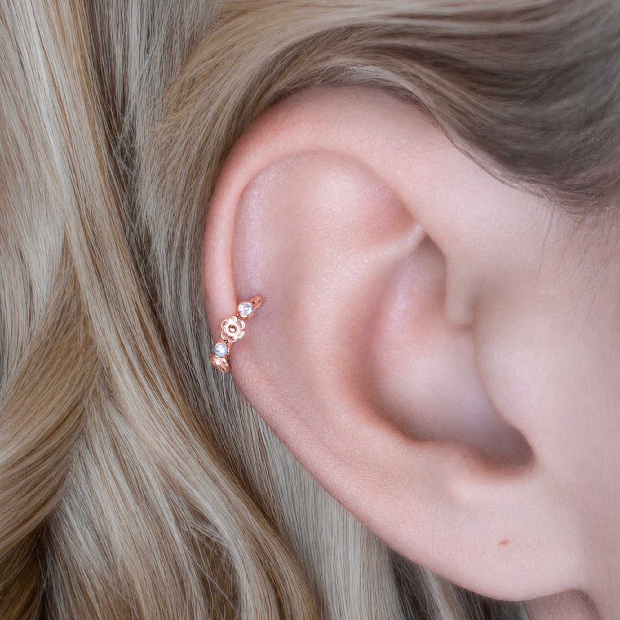 Rose gold ear cuff with floral design and clear stones, elegant piercing jewelry for women