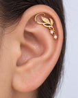 18k gold leaf ear cuff with small pearls on a woman's ear