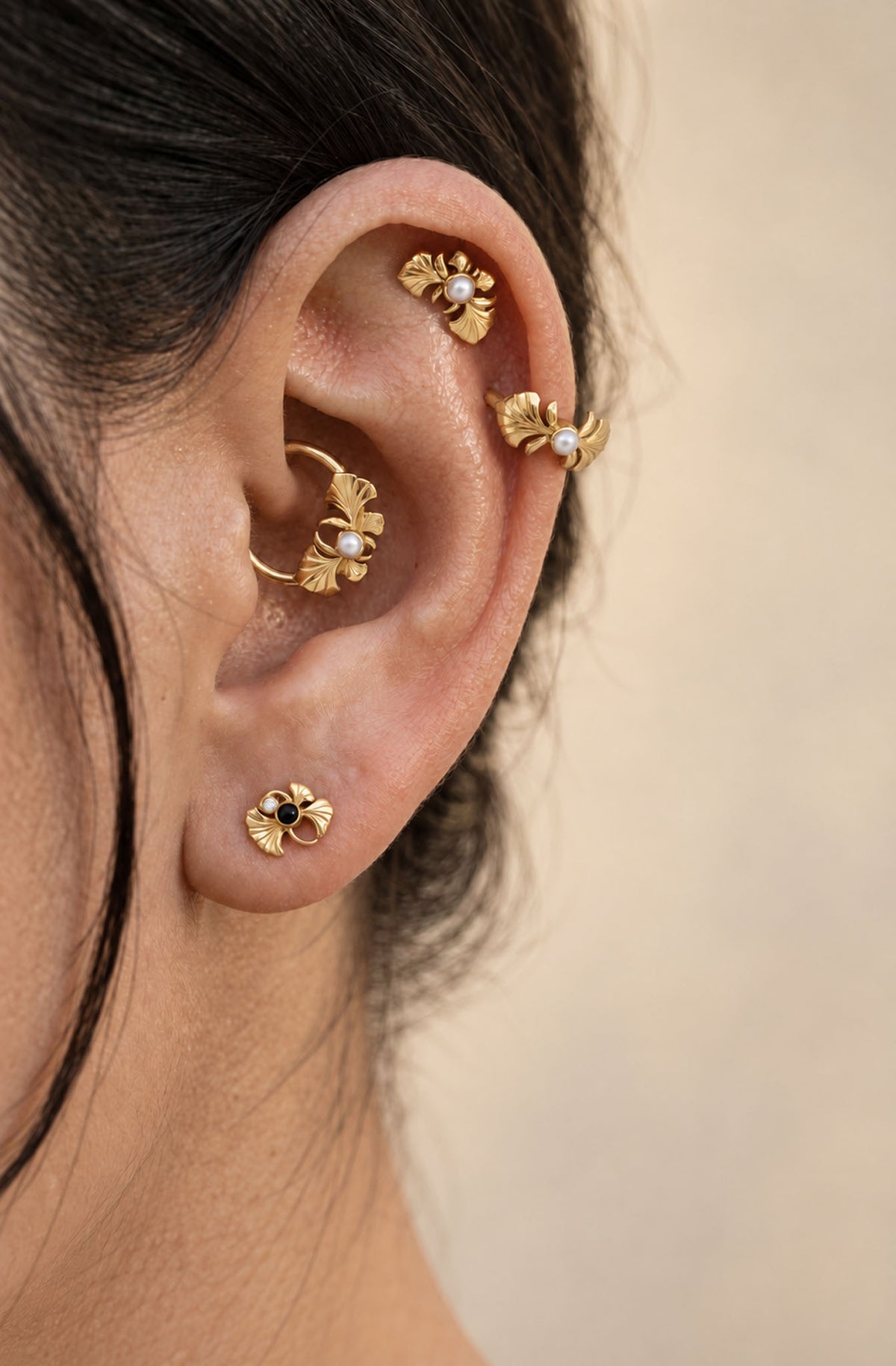 Set of 18k gold ginkgo leaf earrings with pearls in various ear piercings