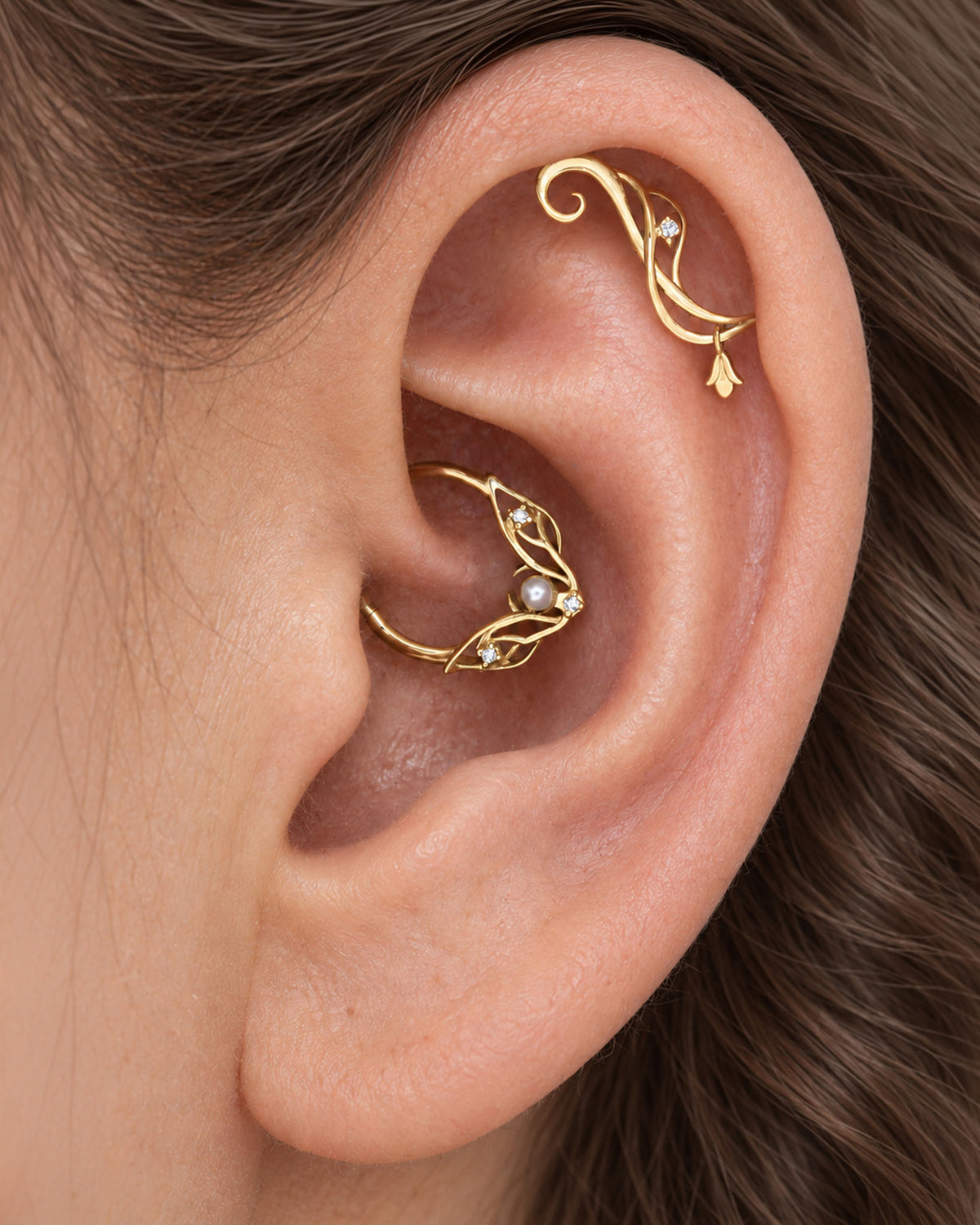 18k gold leaf-design helix and conch piercing jewelry with pearls and diamonds on an ear