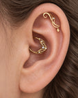 18k gold floral helix and conch piercing jewelry with diamonds and a pearl on a human ear