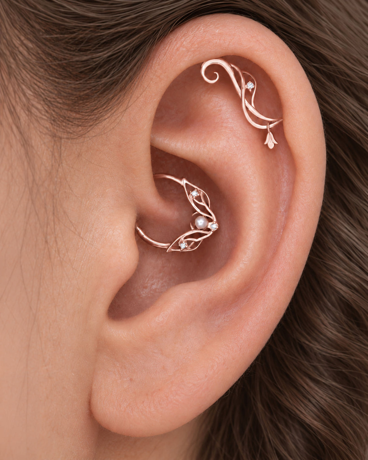 Rose gold leaf and floral piercing jewelry in a human ear