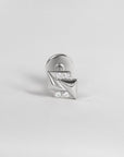 Silver geometric piercing with four round gemstones on white background