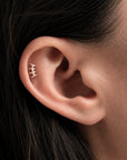 Elegant 18k gold ear piercing with diamonds, showcasing luxury body jewelry for a timeless style.