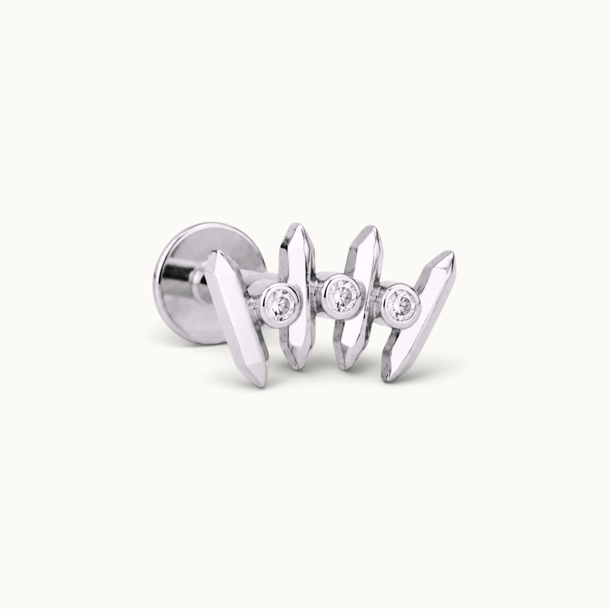18k gold ear piercing with three diamond accents and geometric prong design