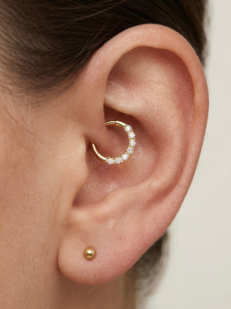 Close-up of ear with a gold cartilage hoop earring adorned with small diamonds