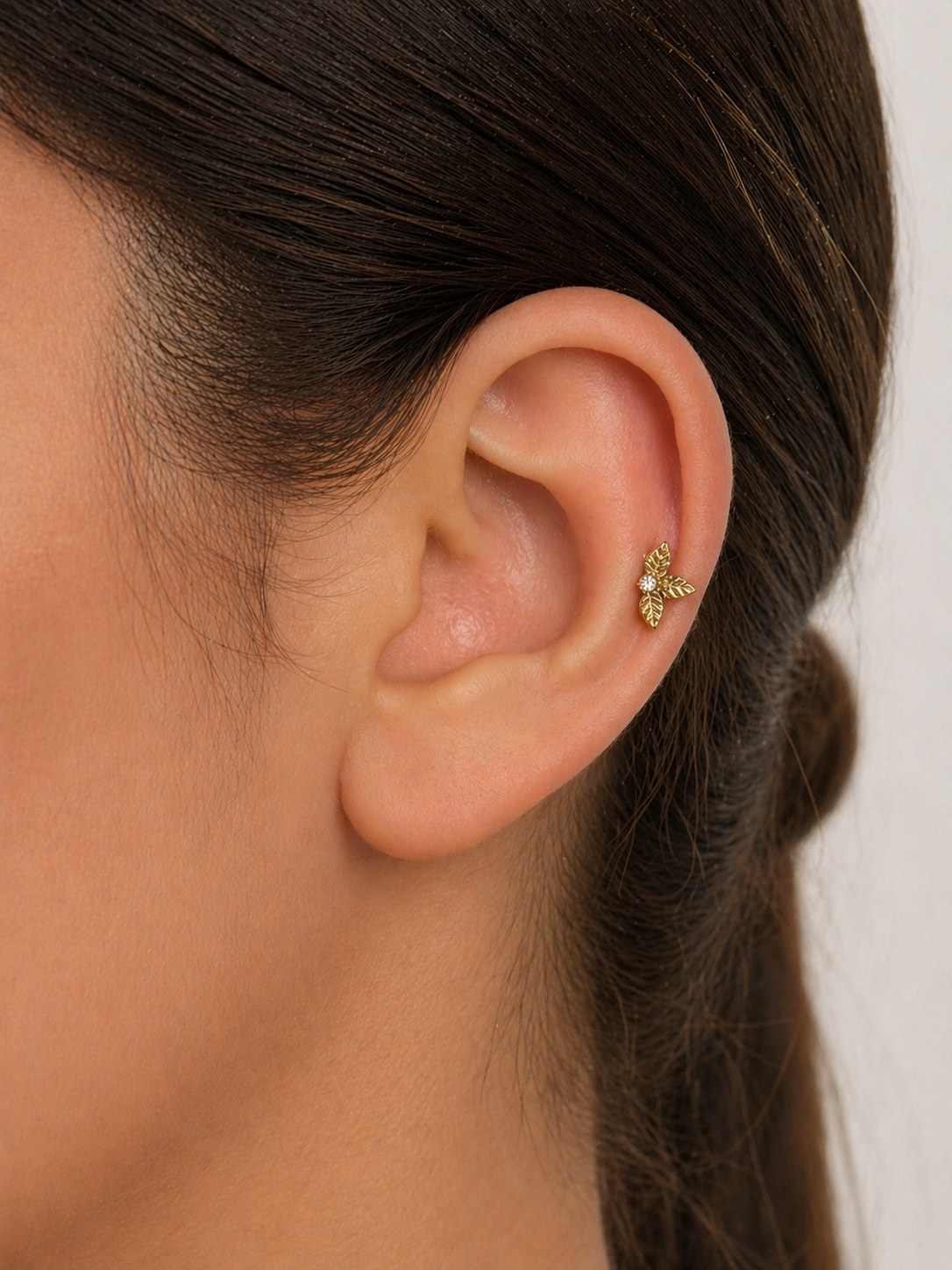 18k gold leaf cartilage earring with diamond on woman's ear