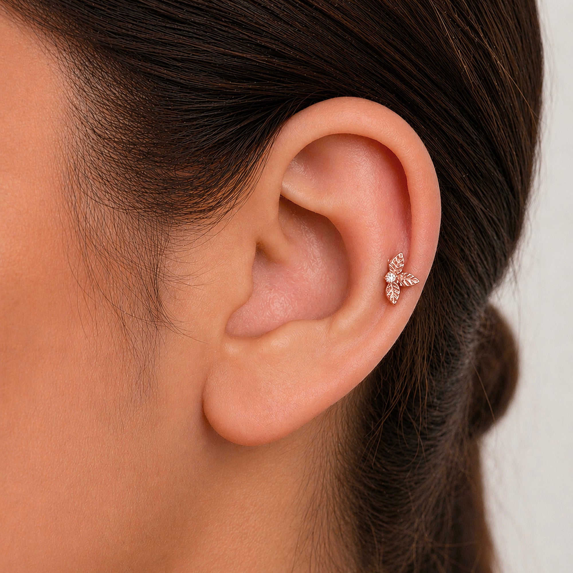 Delicate rose gold leaf ear piercing with diamond accent, luxury 18k gold jewelry for elegant style