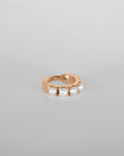 Close up of the Luméa hoop piercing in 18k rose gold adorned with freshwater pearls