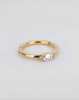 18k gold piercing ring with marquise-cut clear gemstone on white background