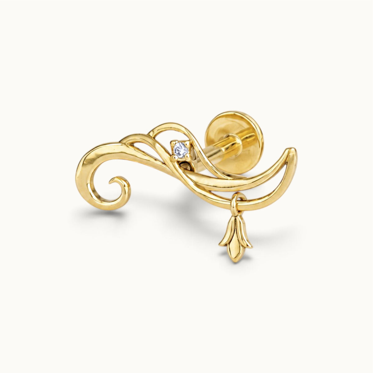 18k gold swirl piercing jewelry with a small diamond and dangling charm