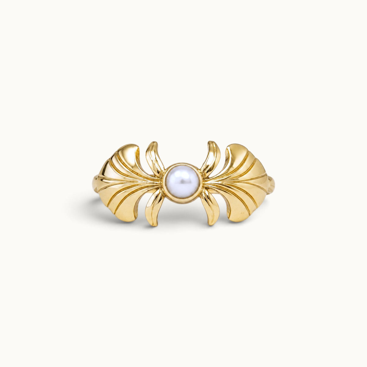 18k gold ring with a central white pearl and stylized golden wings