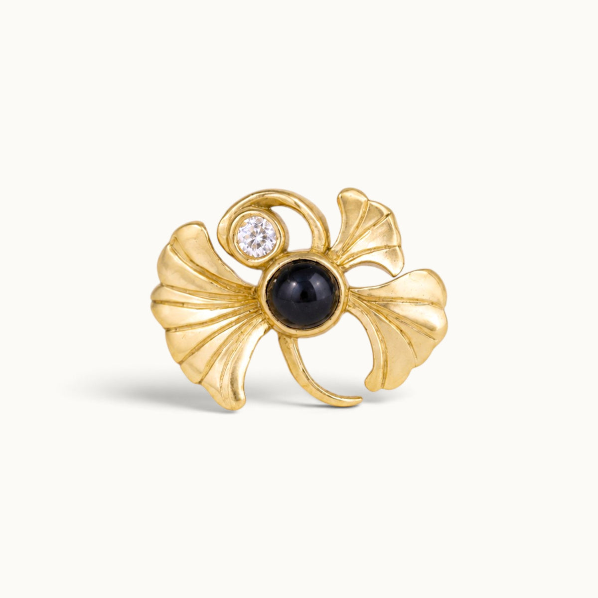 18k gold ginkgo leaf piercing jewelry with a black gemstone and diamond
