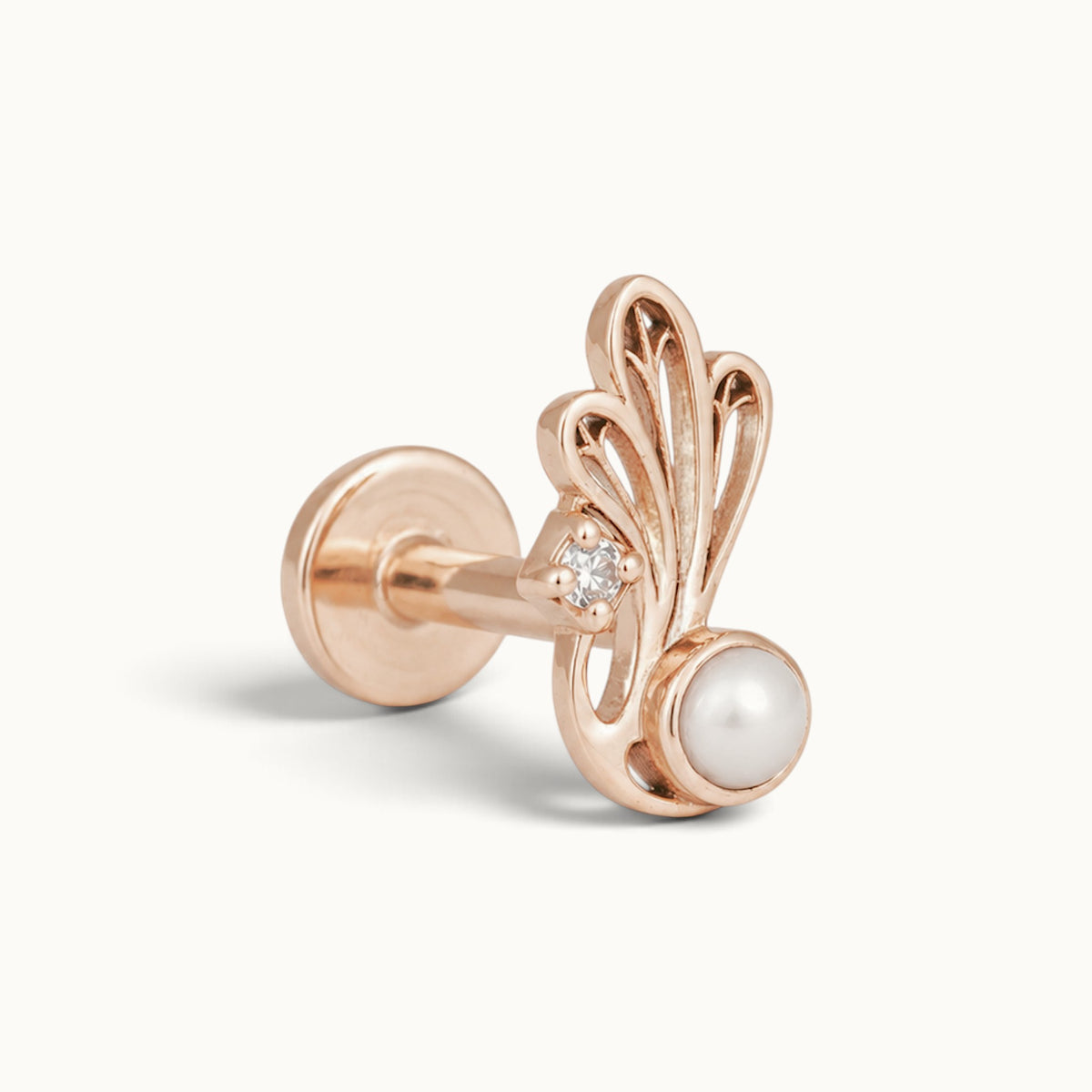Rose gold piercing stud with a white pearl, small diamond, and ornate filigree design.