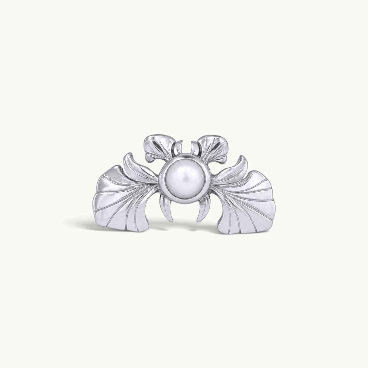 Silver crab-shaped piercing jewelry with a central white pearl on a plain background