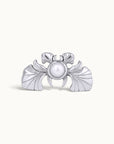 Silver crab-shaped piercing jewelry with a central white pearl on a plain background