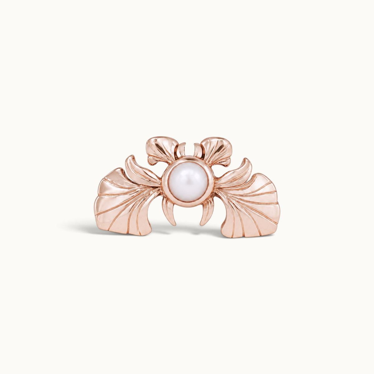 Rose gold piercing jewelry featuring a central white pearl and fan-like wing details.