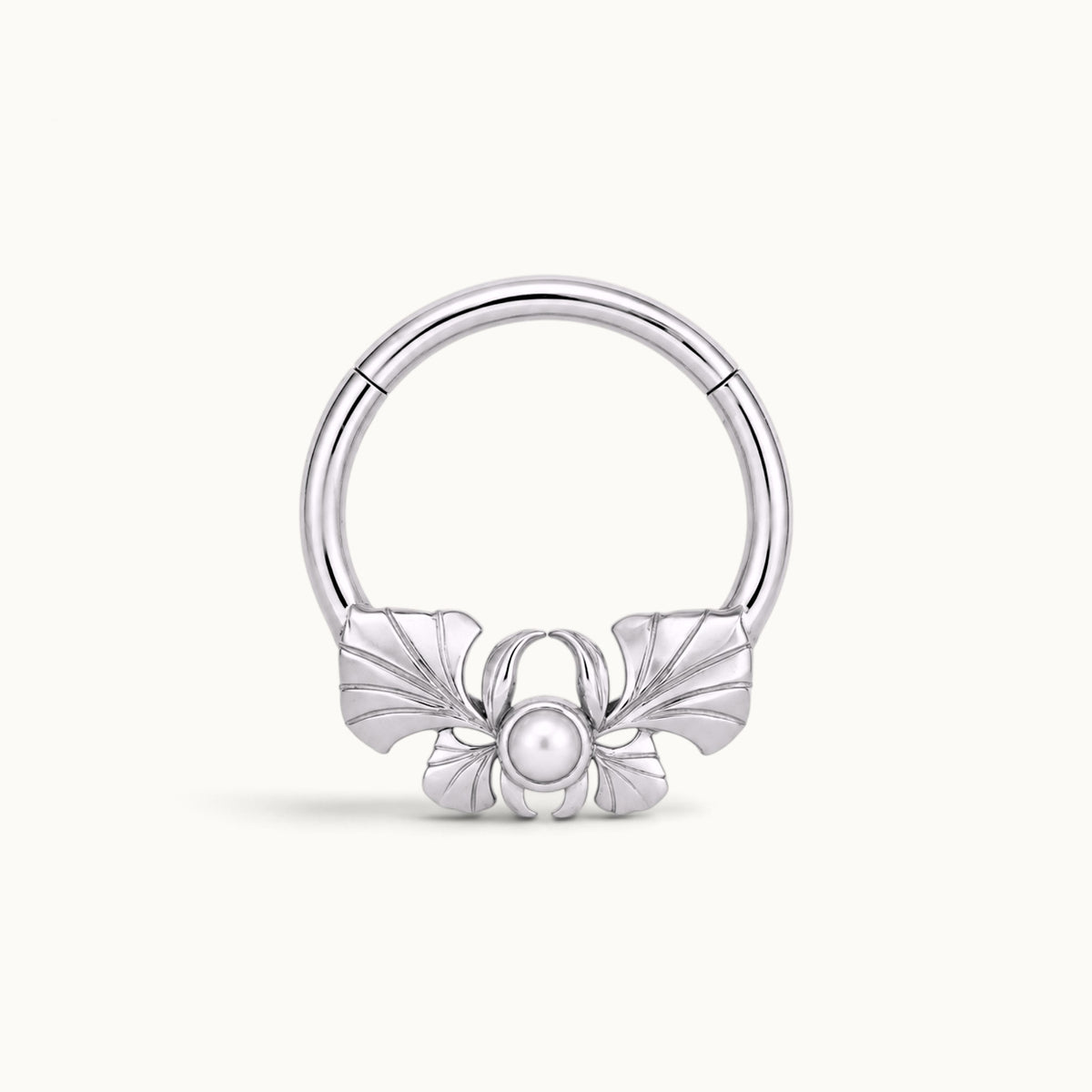 Silver hoop piercing jewelry with a decorative bow and a central pearl