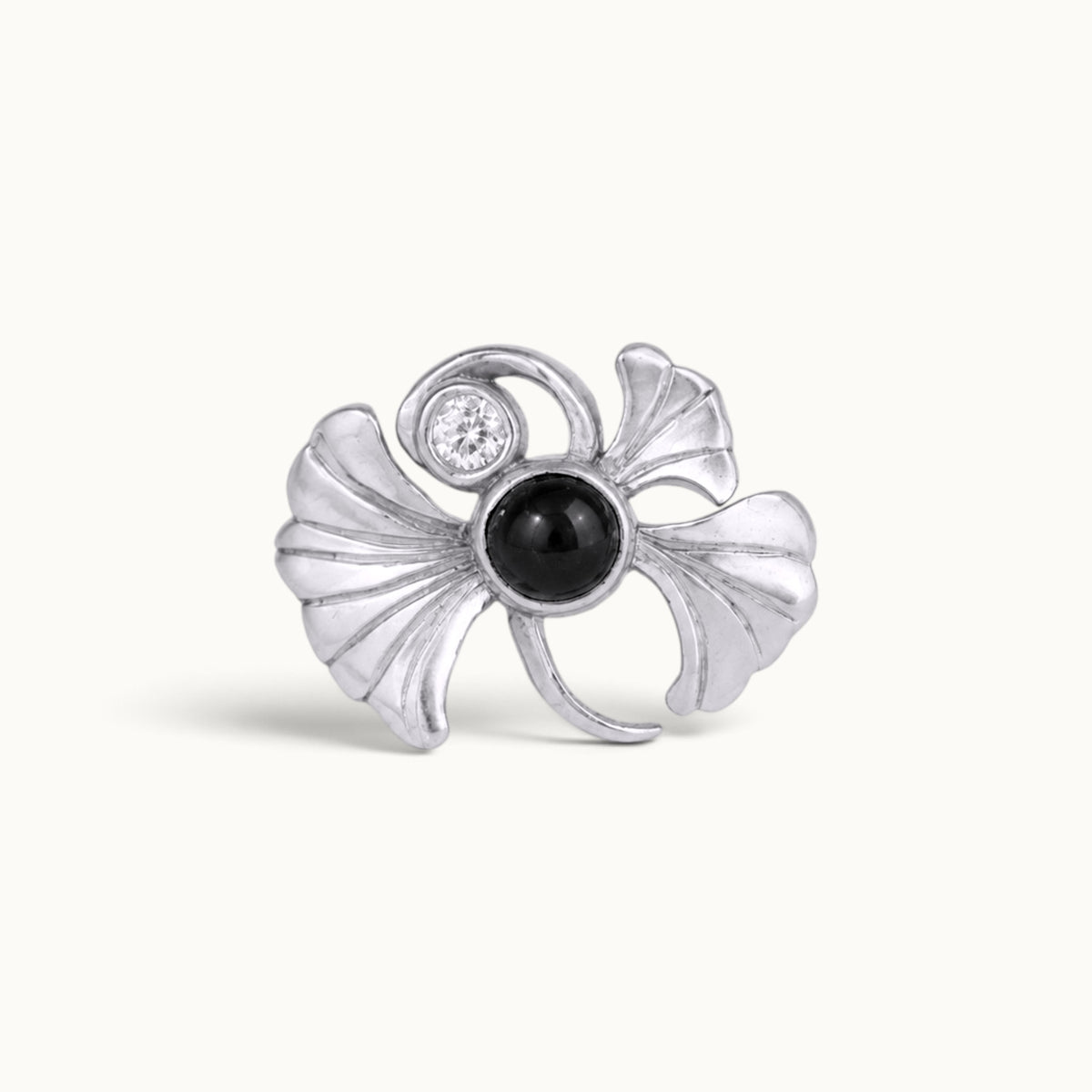 Silver ginkgo leaf piercing jewelry with a black gemstone and a small clear diamond