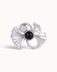 Silver ginkgo leaf piercing jewelry with a black gemstone and a small clear diamond