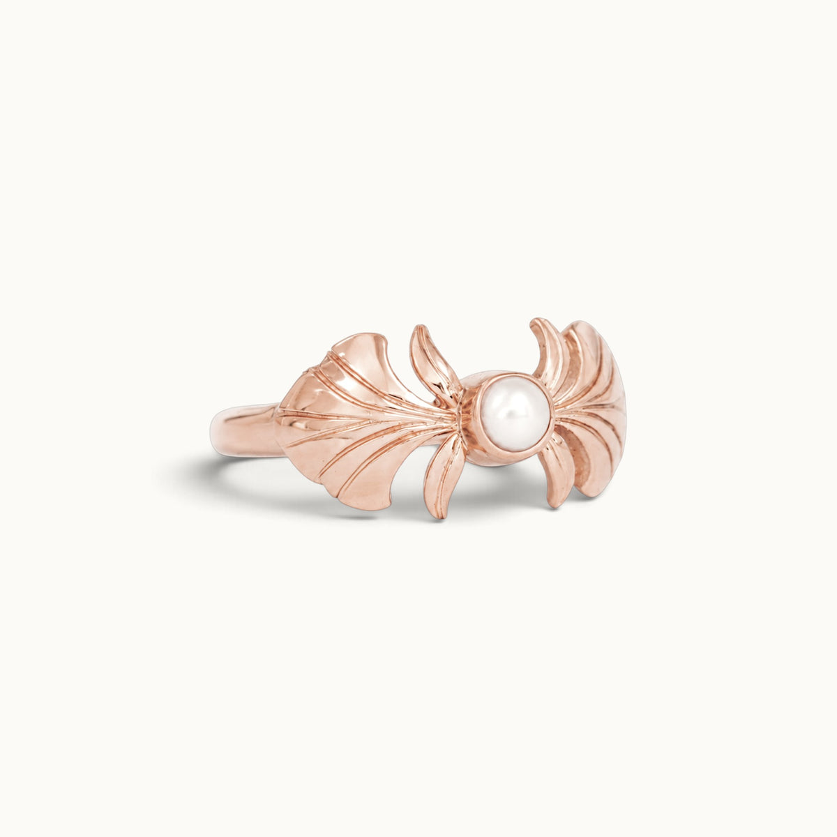 Rose gold ring featuring a central pearl and sculpted wing-like designs