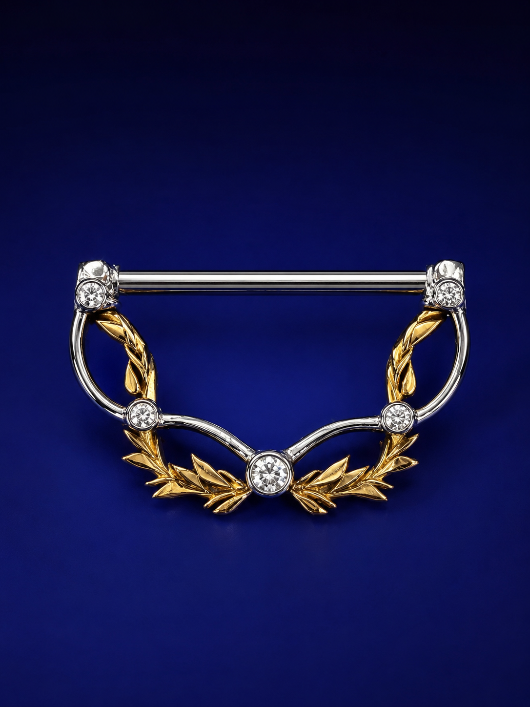 Gold and silver custom nipple ring with laurel leaf design and diamonds on blue background