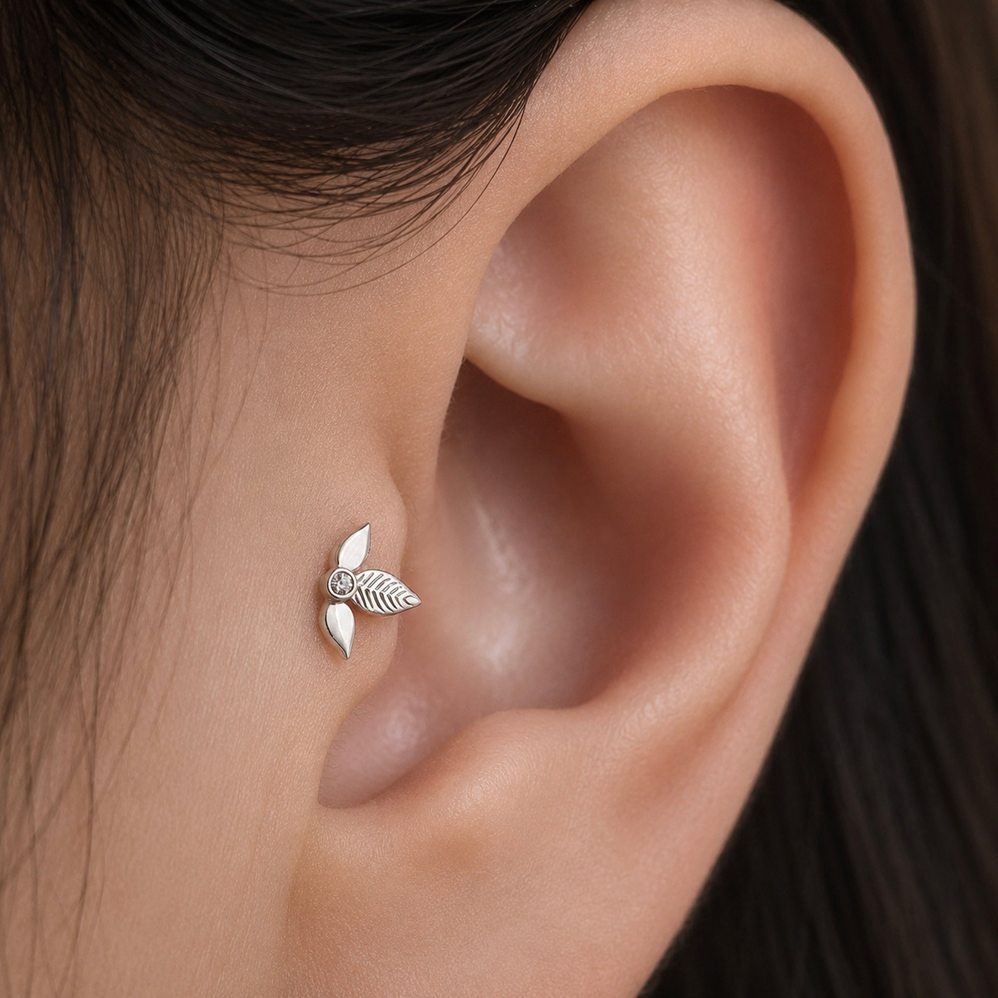 Delicate leaf-shaped 18k gold ear piercing with diamond accent, elegant fine jewelry for lobe piercings