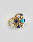 Large piercing ring set with several gemstones in 18k yellow gold